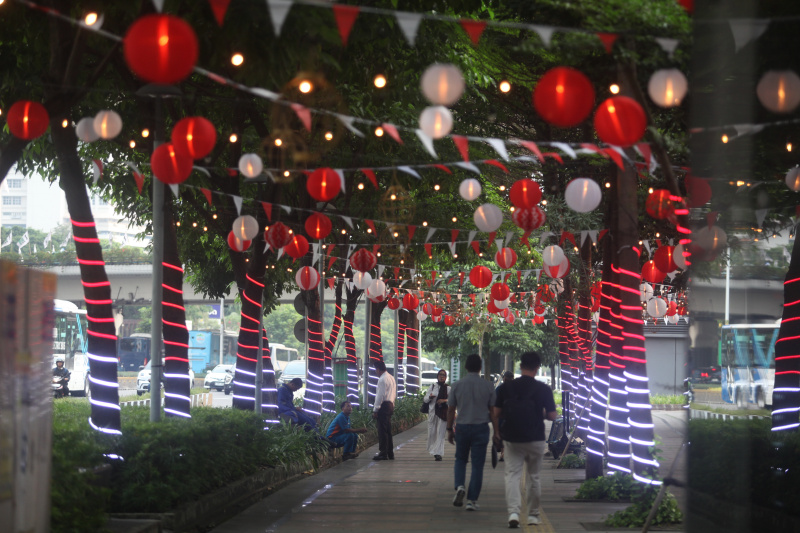 Ornamen lampu merah-putih menghiasi trotoar jalan Sudirman dalam rangka sambut HUT ke-80 RI (Ashar/SinPo.id)