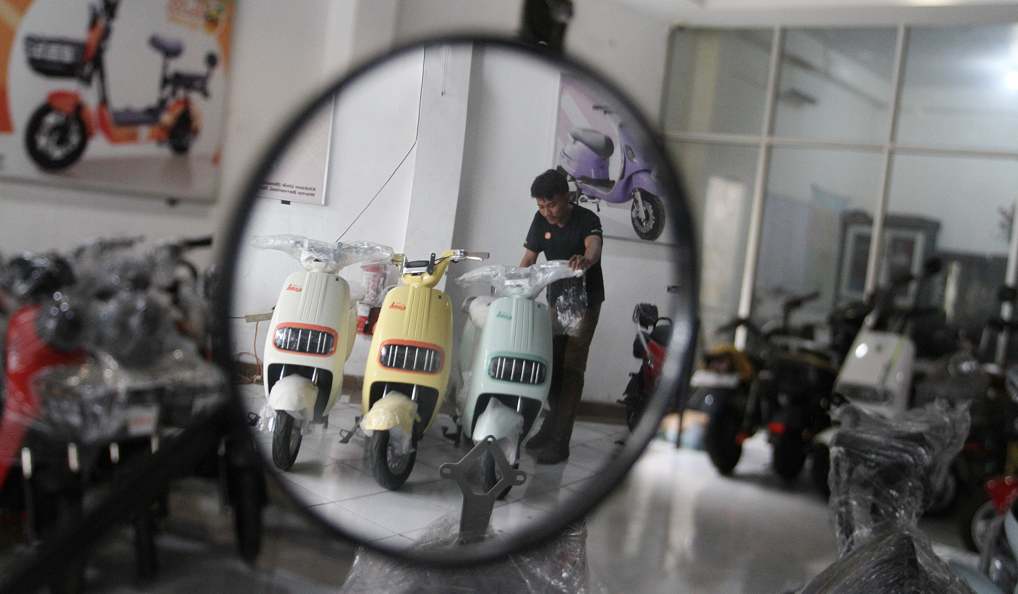 Pekerja melakukan pengecekan motor listrik di salah satu showroom di Jakarta, Senin (7 Juli 2025).