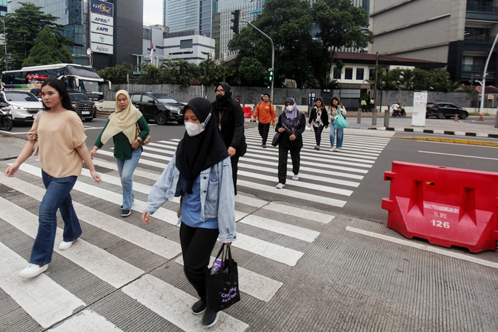 Pekerja sedang melintas di jalan Sudirman usai beraktivitas (Ashar/SinPo.id)