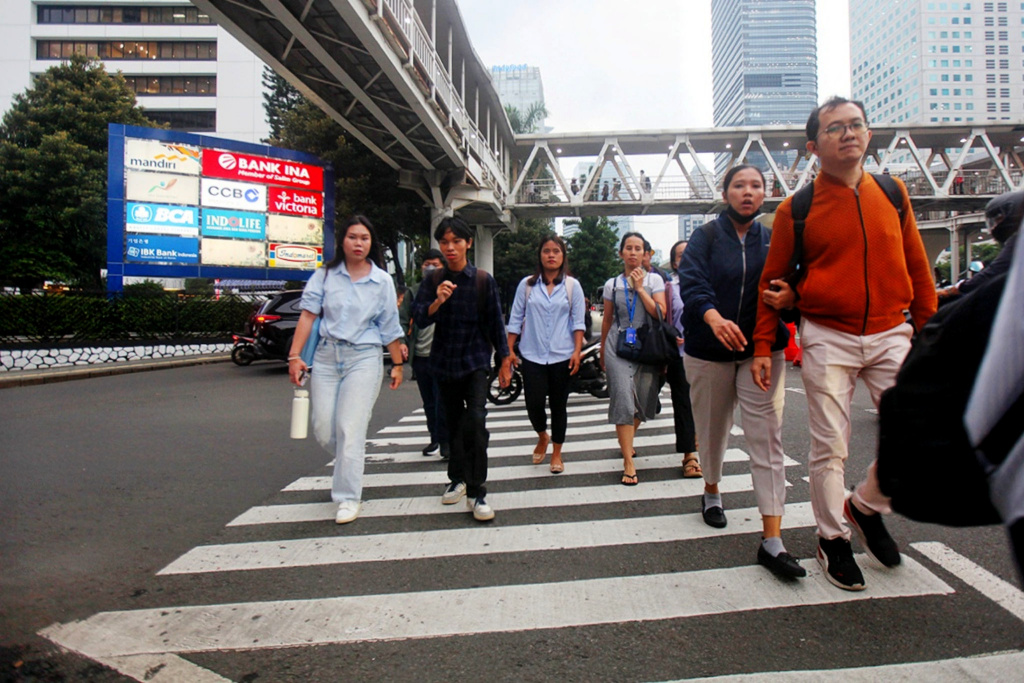 Pekerja sedang melintas di jalan Sudirman usai beraktivitas (Ashar/SinPo.id)