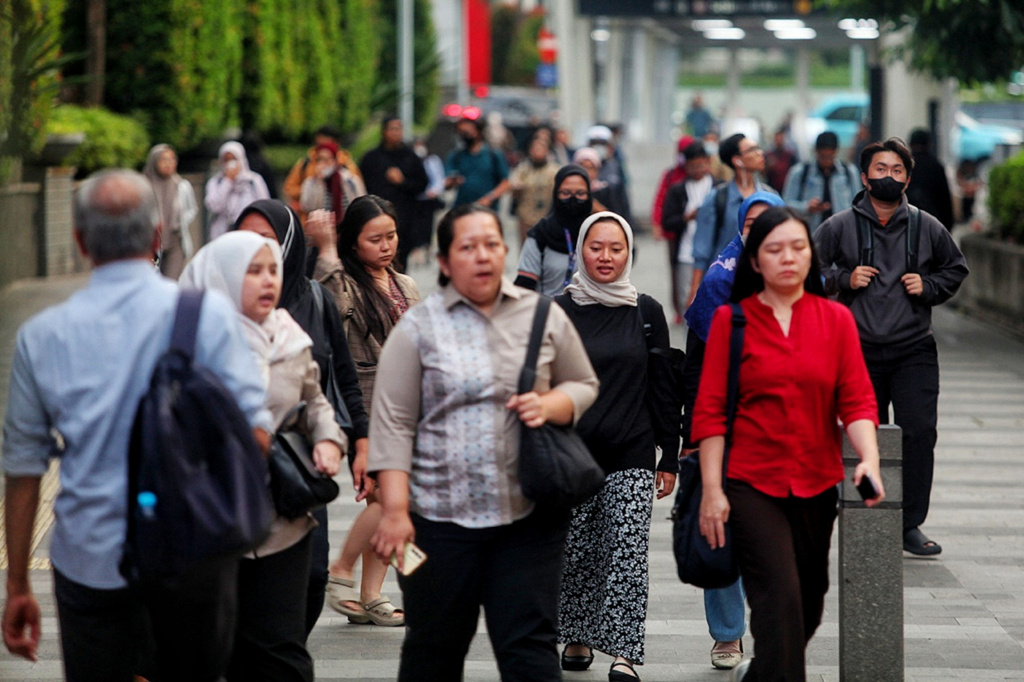 Pekerja sedang melintas di jalan Sudirman usai beraktivitas (Ashar/SinPo.id)