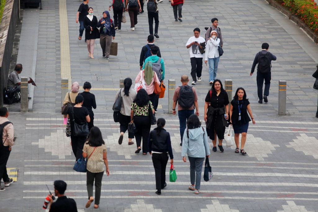 Pekerja sedang melintas di jalan Sudirman usai beraktivitas (Ashar/SinPo.id)