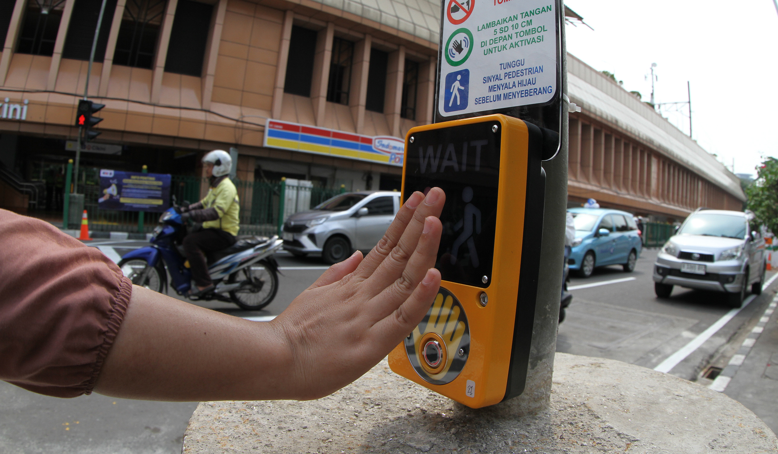 Warga melintasi pelican crossing di Stasiun Cikini. (Agus Priatna/SinPo.id)