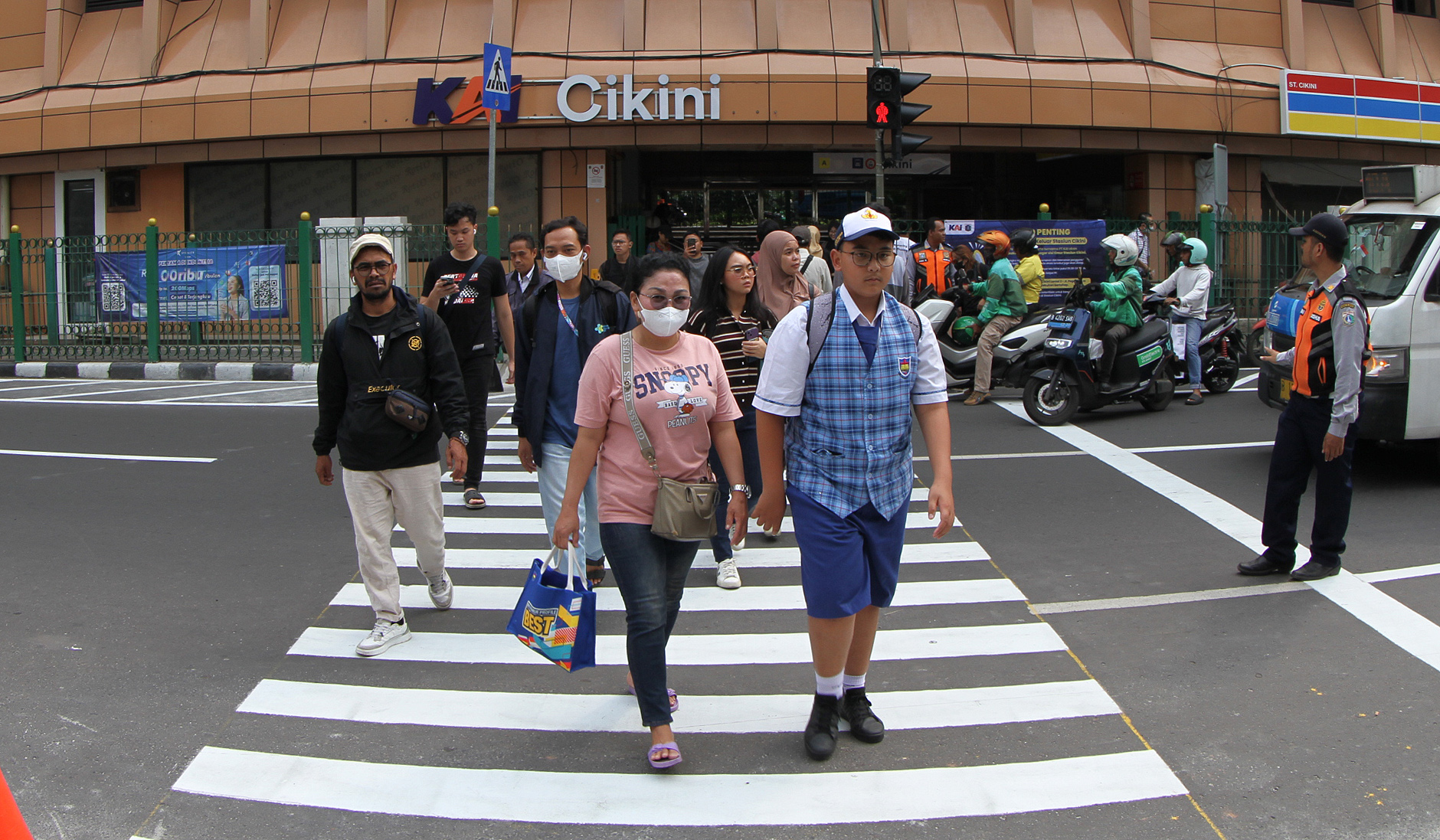 Warga melintasi pelican crossing di Stasiun Cikini. (Agus Priatna/SinPo.id)