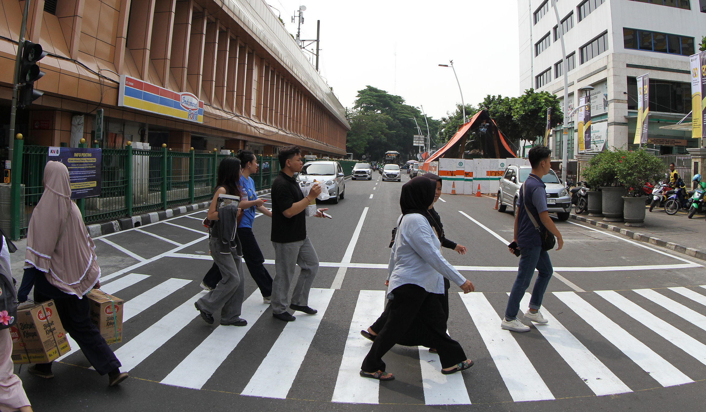 Warga melintasi pelican crossing di Stasiun Cikini. (Agus Priatna/SinPo.id)