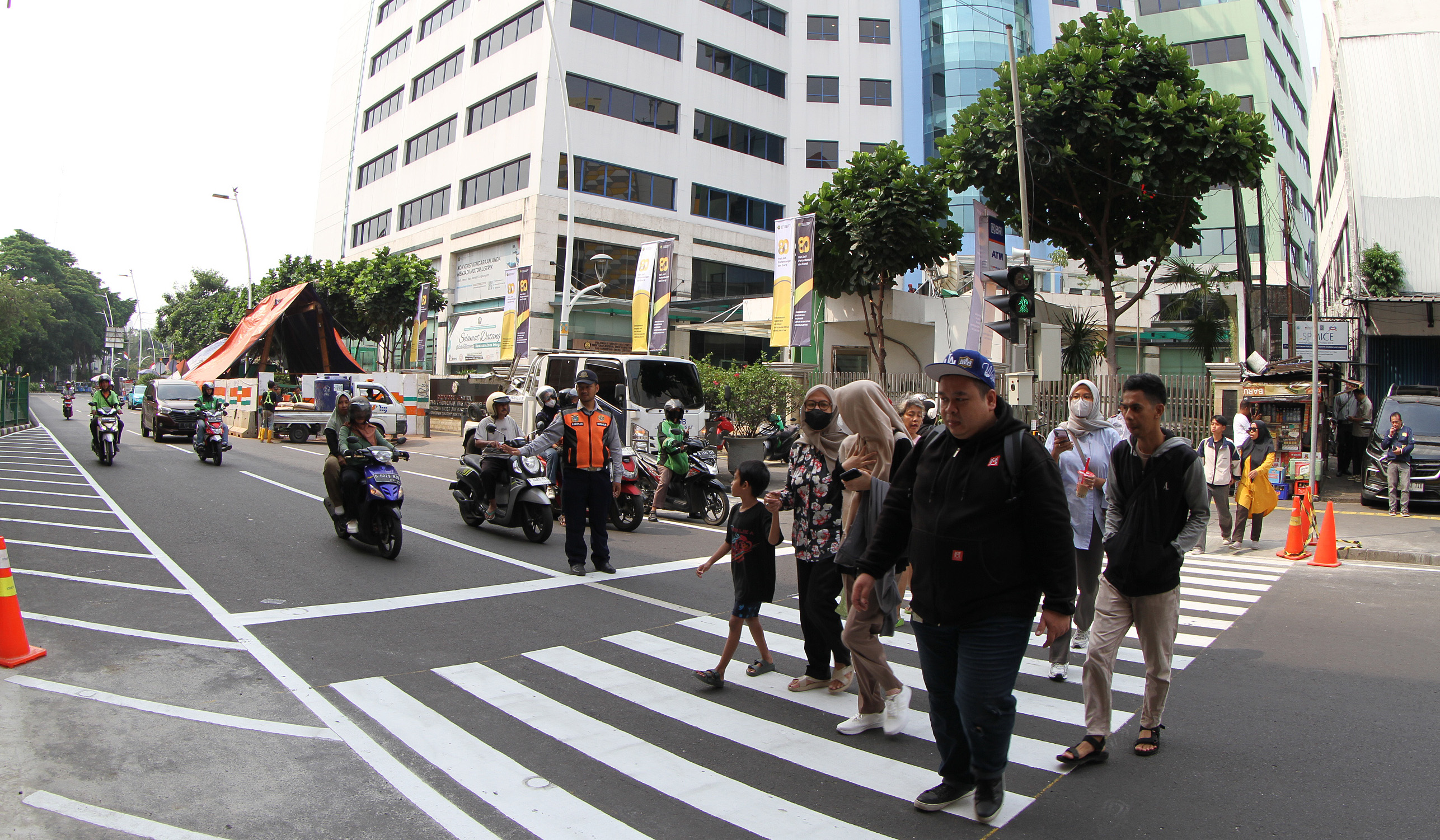 Warga melintasi pelican crossing di Stasiun Cikini. (Agus Priatna/SinPo.id)