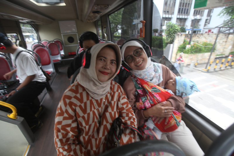 Wisatawan sedang menikmati layanan bus wisata Open Top Tour of Jakarta (Ashar/SinPo.id)