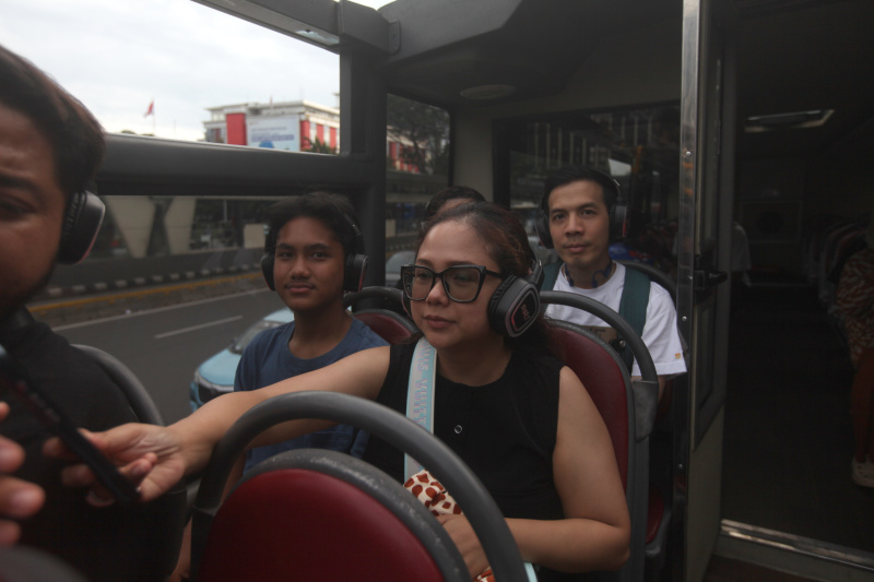 Wisatawan sedang menikmati layanan bus wisata Open Top Tour of Jakarta (Ashar/SinPo.id)