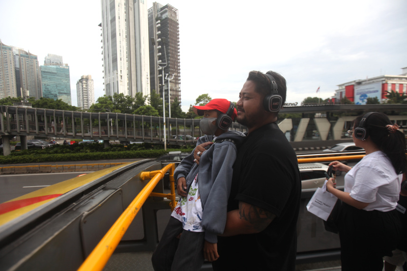 Wisatawan sedang menikmati layanan bus wisata Open Top Tour of Jakarta (Ashar/SinPo.id)