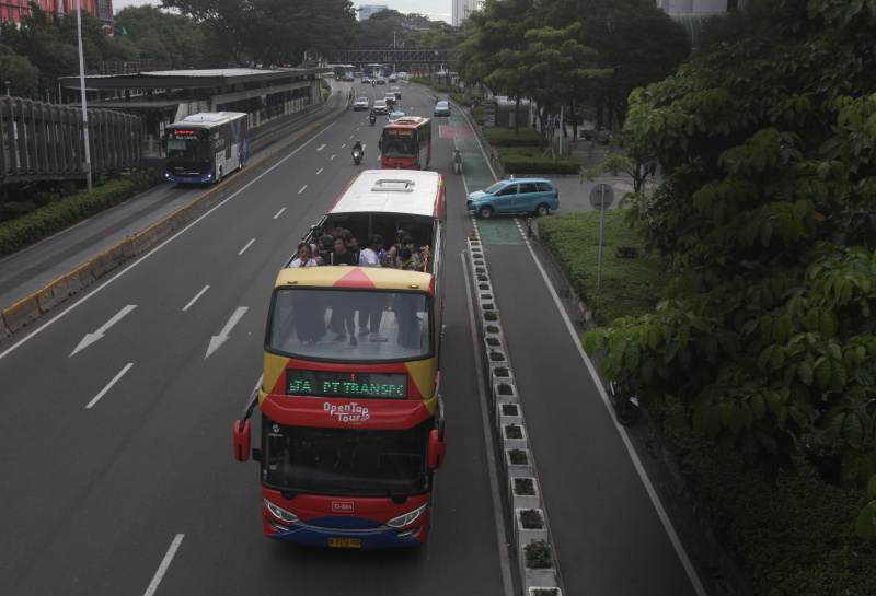 Wisatawan sedang menikmati layanan bus wisata Open Top Tour of Jakarta (Ashar/SinPo.id)