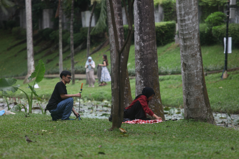 Warga sedang menikmati liburan panjang Hari Raya Waisak di Taman Langsat (Ashar/SinPo.id)