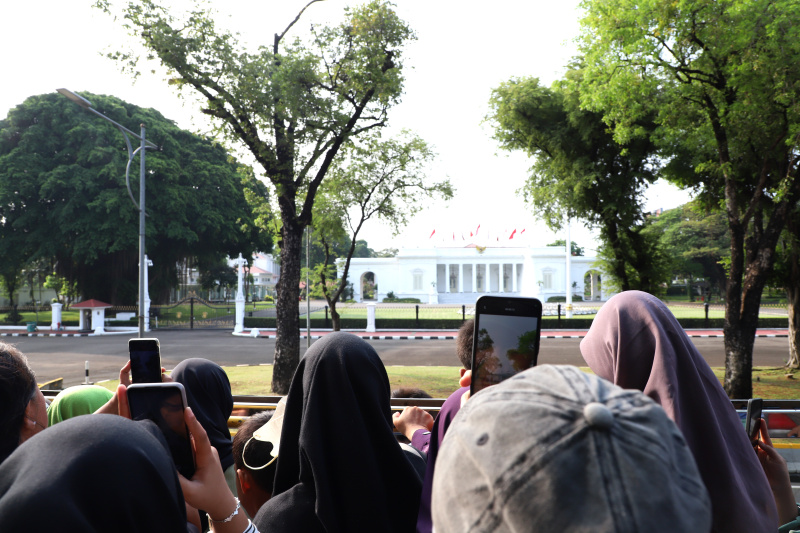 Warga mengantre untuk menaiki bus tingkat wisata atap terbuka Transjakarta di halte Irti Monas (Ashar/SinPo.id)