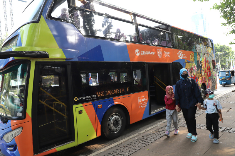 Warga mengantre untuk menaiki bus tingkat wisata atap terbuka Transjakarta di halte Irti Monas (Ashar/SinPo.id)