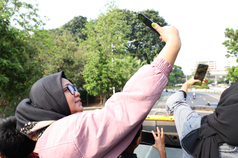 Warga mengantre untuk menaiki bus tingkat wisata atap terbuka Transjakarta di halte Irti Monas (Ashar/SinPo.id)