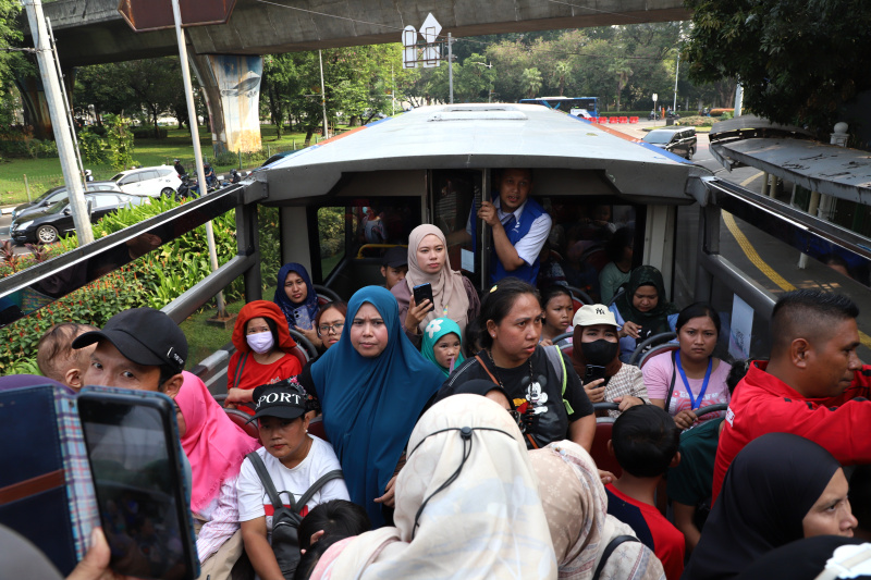 Warga mengantre untuk menaiki bus tingkat wisata atap terbuka Transjakarta di halte Irti Monas (Ashar/SinPo.id)