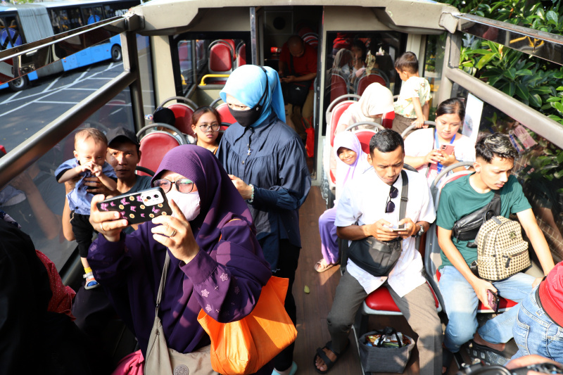 Warga mengantre untuk menaiki bus tingkat wisata atap terbuka Transjakarta di halte Irti Monas (Ashar/SinPo.id)